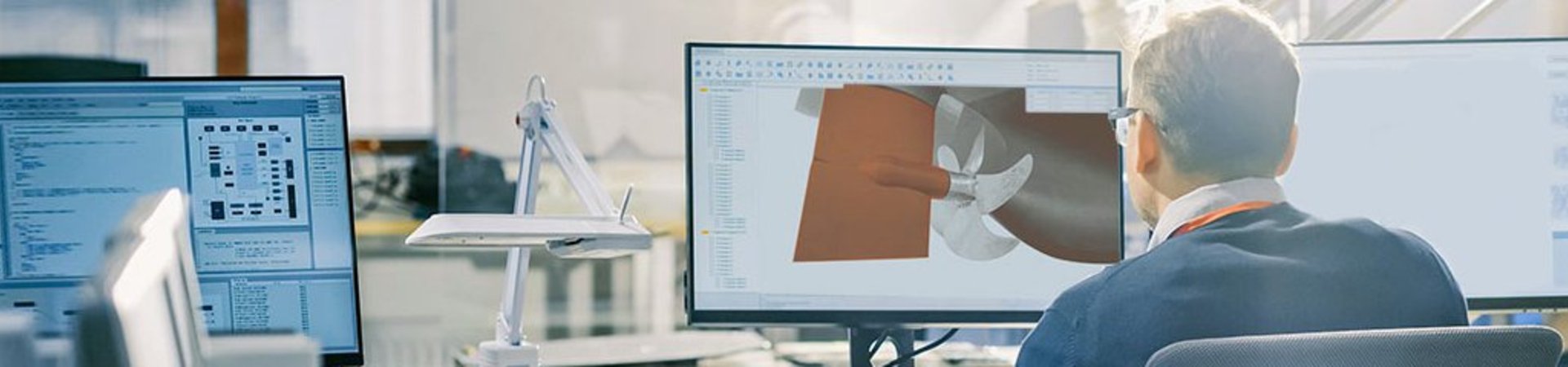 Engineer sitting at desk in front of a comupter screen designing a rudder solution